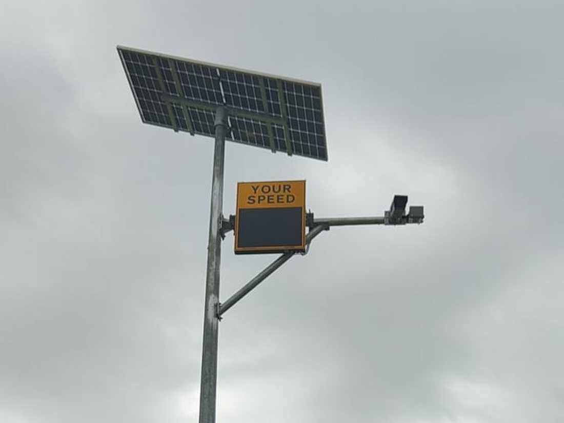 Complete off-grid 3-Digit installation on a rural highway: solar panel, radar speed display, ANPR camera and battery cabinet on one pole